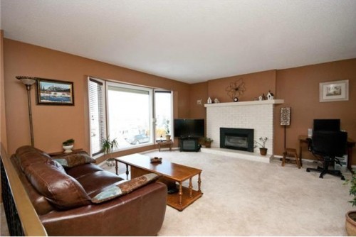 Spacious living room with a mountain view through the bay window in this home for sale in BX area of Vernon BC listed by John Deak of Royal LaPage.